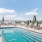 a pool with chairs and umbrellas by a beach